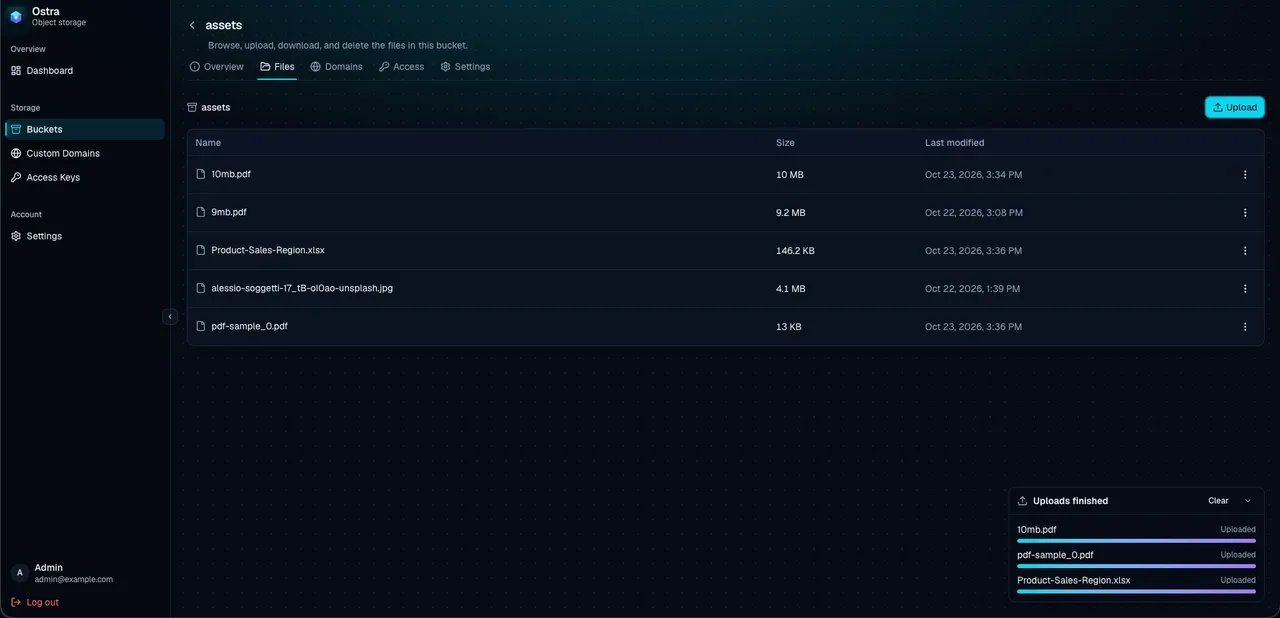 Ostra bucket file manager showing uploaded objects with progress indicators in a dark UI